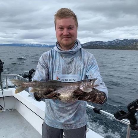 Angler dressed completely in Dagon apparel showing fish in camera