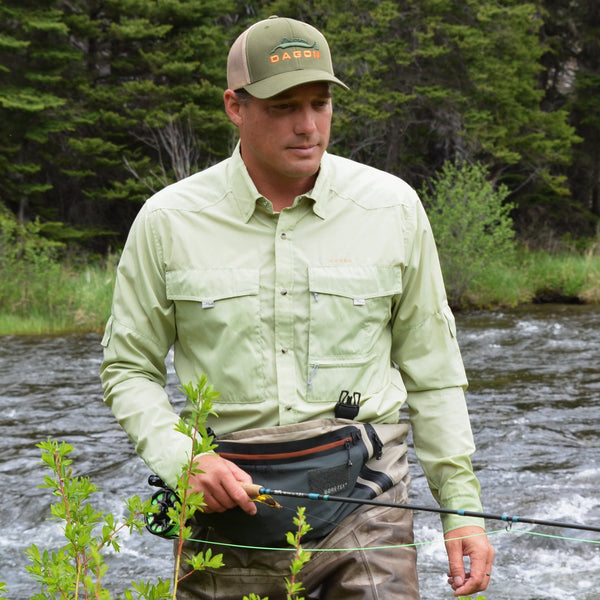 Man is wearing pear colored shirt for fly fishing.
