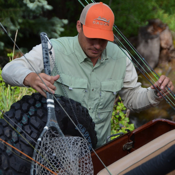 Angler in Dagon fishing apparel gearing up equipment for a fishing trip.
