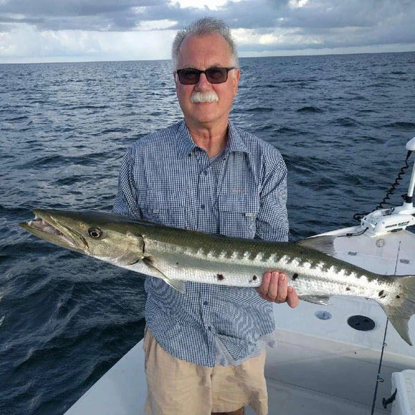 An old man catch a big fish on boat wearing Navy Gingham Shirt.